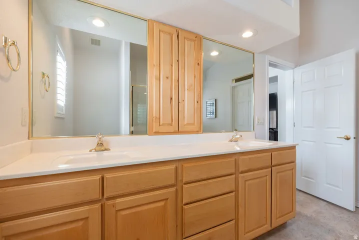Light wood-finish vanity with dual sinks and a white countertop