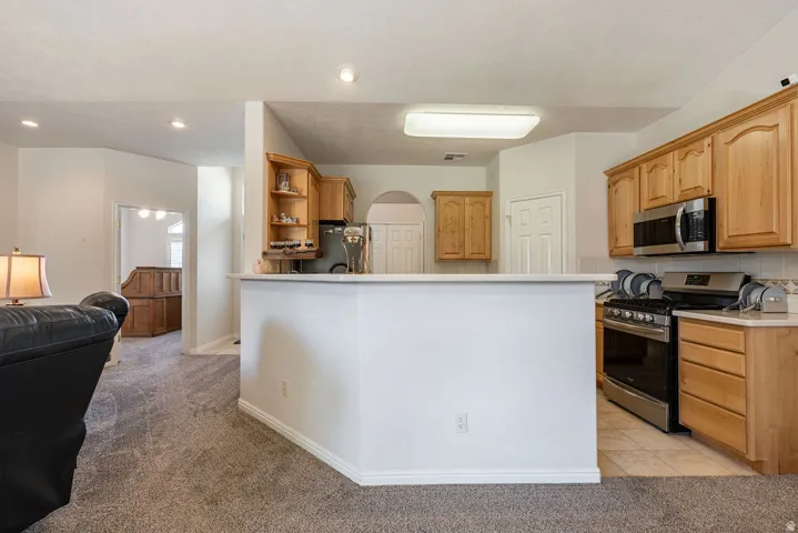Kitchen with wood cabinetry, stainless steel appliances, and a tiled backsplash