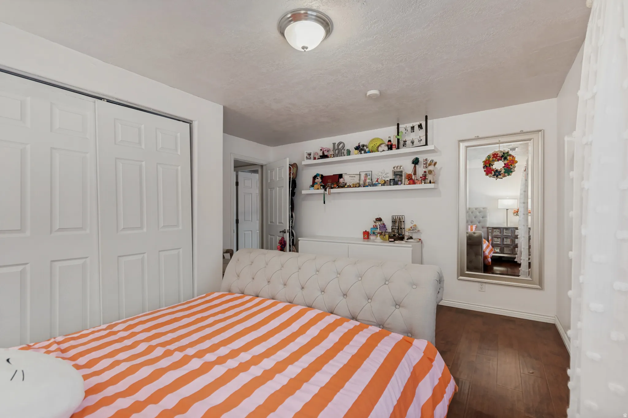 Wood-finish flooring with white walls and a ceiling-mounted light fixture