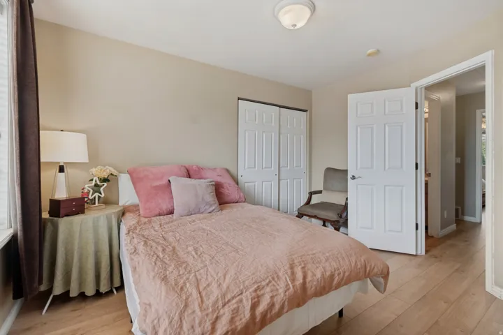 Wood-finish flooring, neutral wall tones, and white bi-fold closet doors