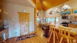 Vaulted wood-paneled ceiling, wood-finish flooring, stainless steel appliances, breakfast bar, and wood cabinetry
