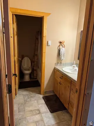 Wood-finish cabinetry and trim, integrated vanity sink, and tiled flooring