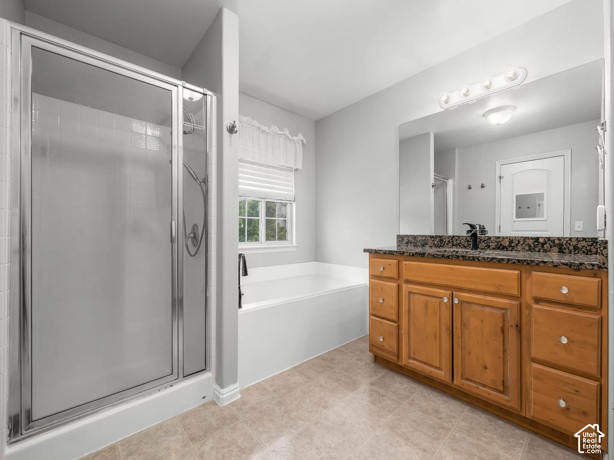 Tile flooring with a single vanity featuring a stone countertop