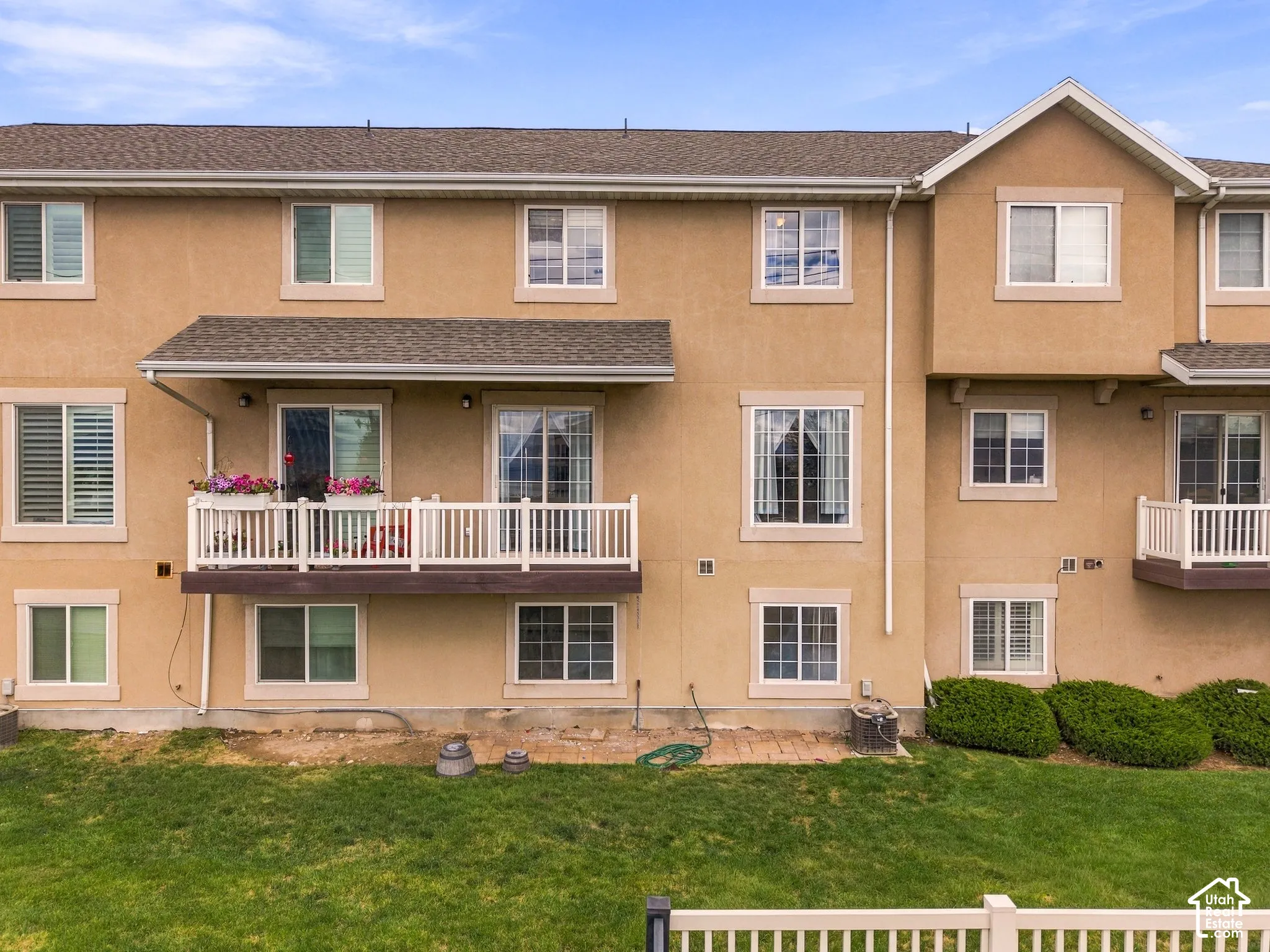 Rear exterior with stucco siding, multiple windows, and private balconies