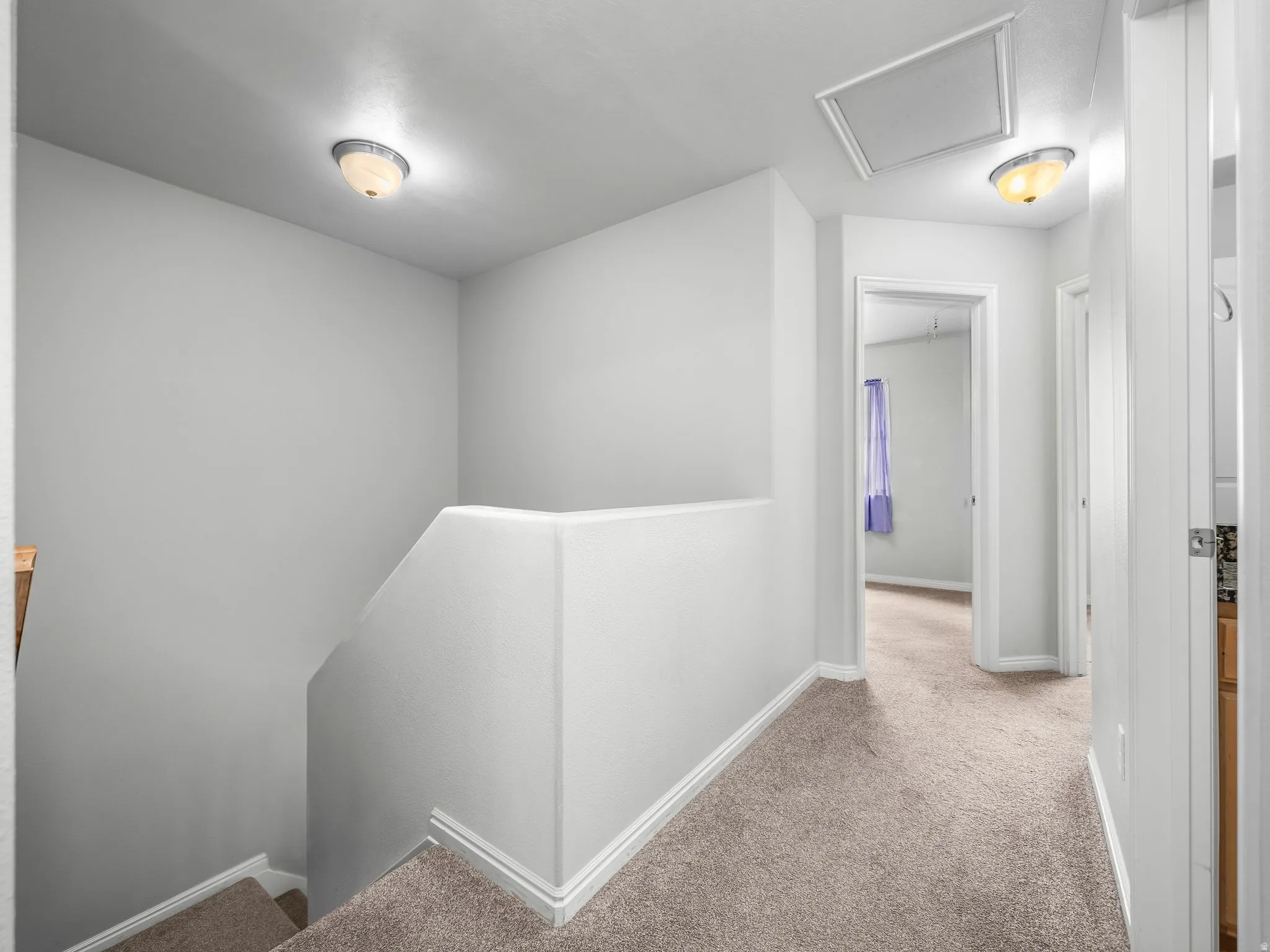 Neutral tone wall paint, carpeted flooring, flush mount ceiling lights, white trim, and a ceiling access panel