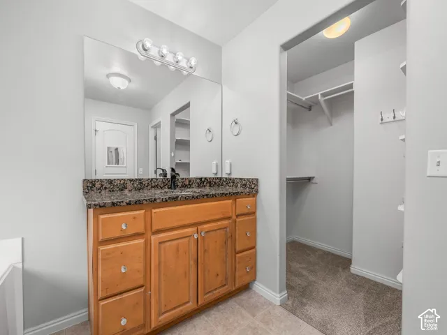 Wood-finish vanity with a dark speckled countertop