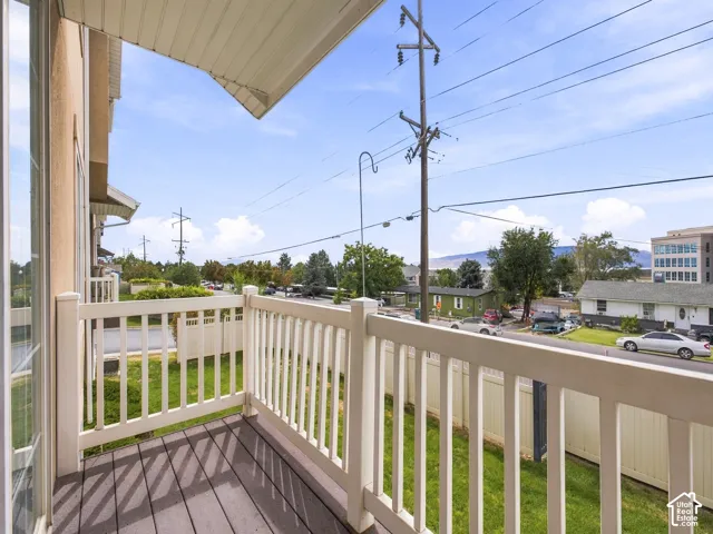 Balcony with composite decking and white railing, offering an elevated perspective of the surrounding area