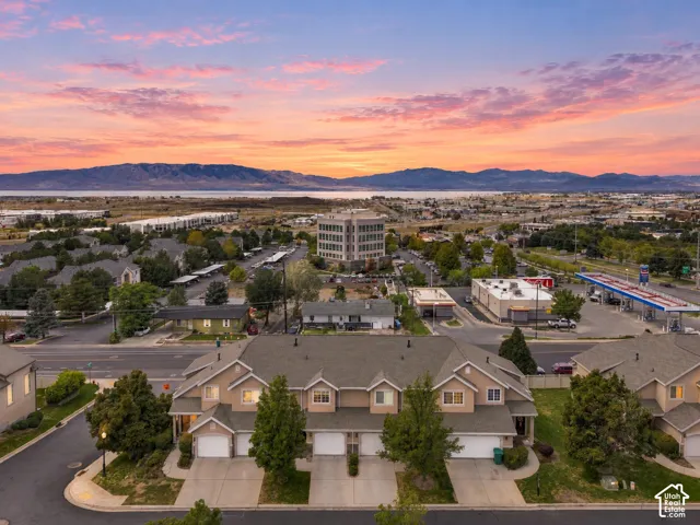 Townhome exterior with attached garages, paved driveways, and mature landscaping