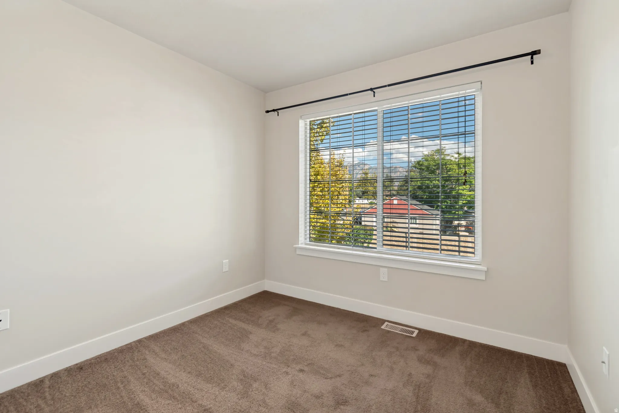 Neutral-toned carpeted flooring complements the light wall color