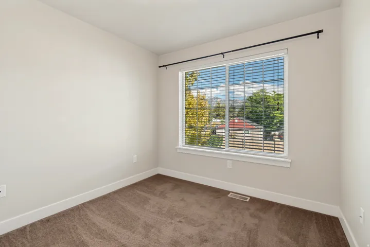 Neutral-toned carpeted flooring complements the light wall color
