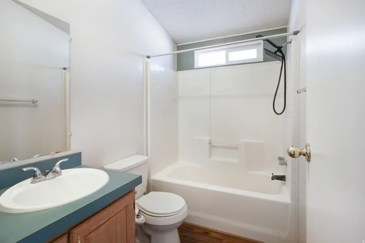 Bathroom featuring a vanity with a white oval sink, chrome faucet, and wood-finish cabinetry