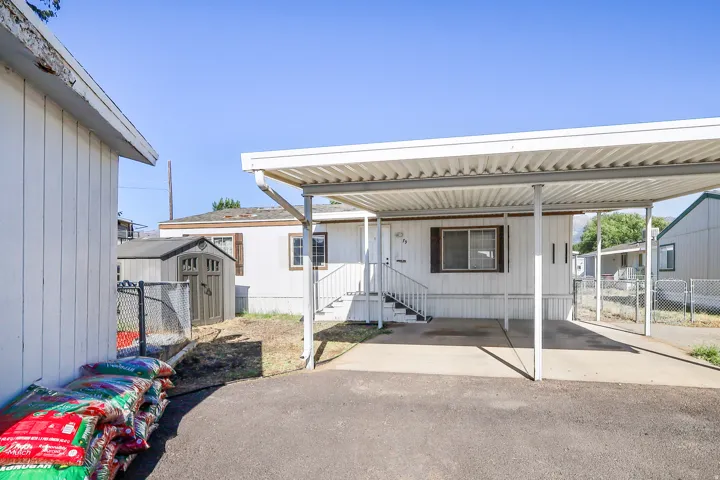 Carport with a concrete pad and white aluminum frame