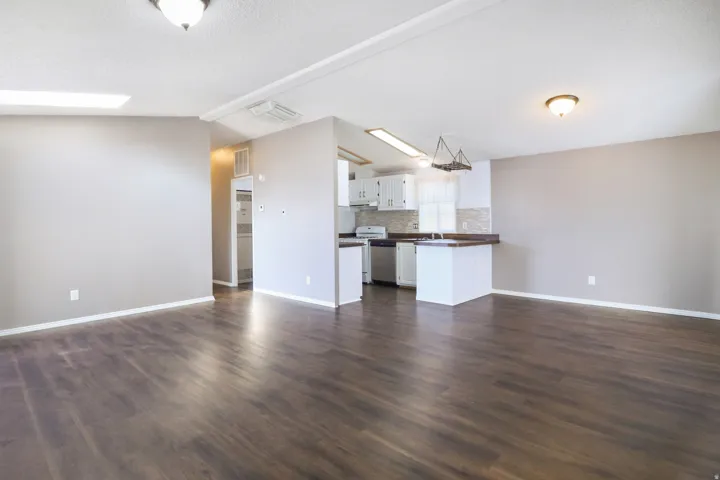 Wood-finish flooring, recessed lighting, and a skylight illuminate this living area