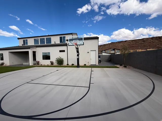 Expansive backyard featuring artificial turf, a built-in trampoline, sport court and full landscaping