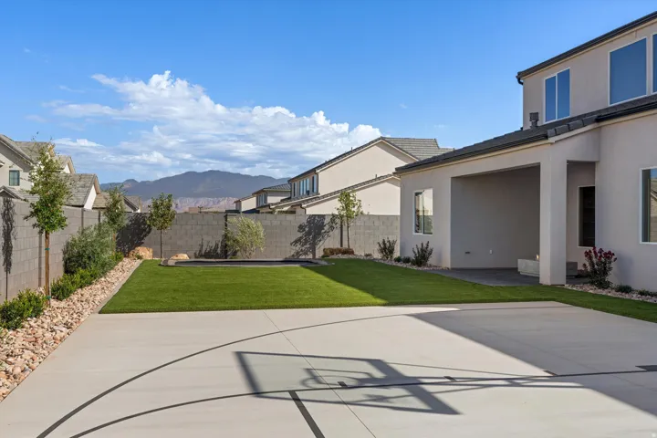 Expansive backyard featuring artificial turf, a built-in trampoline, sport court and full landscaping