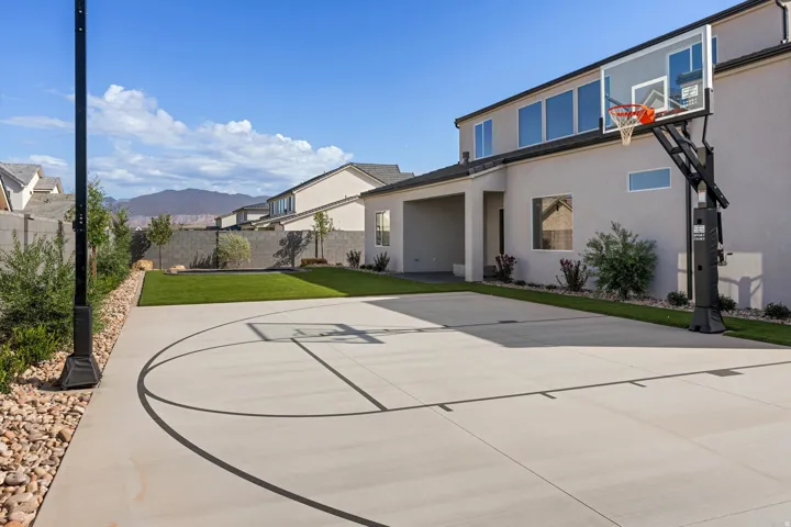 Expansive backyard featuring artificial turf, a built-in trampoline, sport court and full landscaping