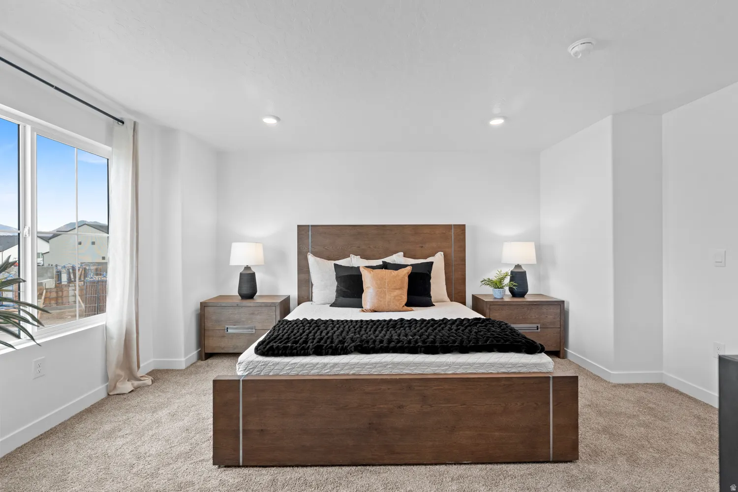 Carpeted flooring, recessed lighting, and a large window with white trim