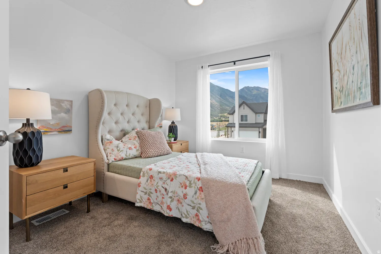 Carpeted room with white walls, a large window, and mountain scenery