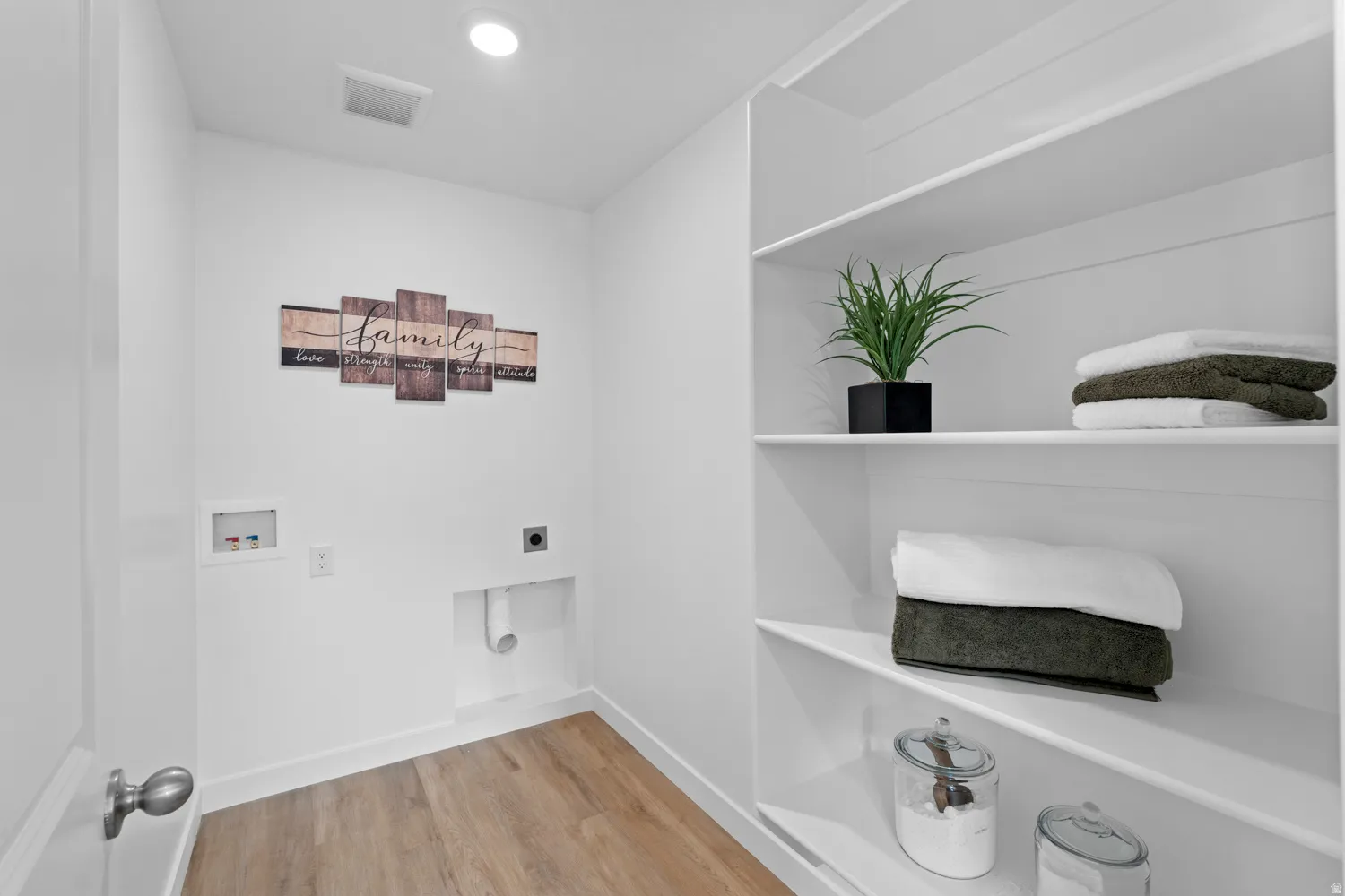 Laundry room with built-in open shelving, wood-finish flooring, recessed lighting, and white walls