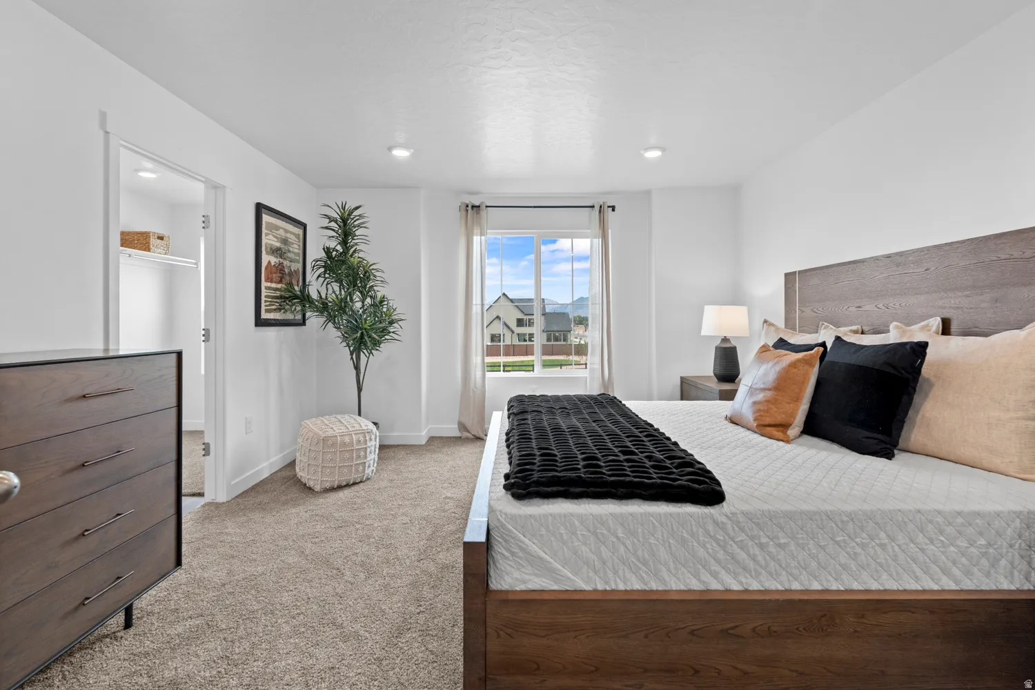 Plush carpeting, recessed lighting, and a window with a mountain backdrop