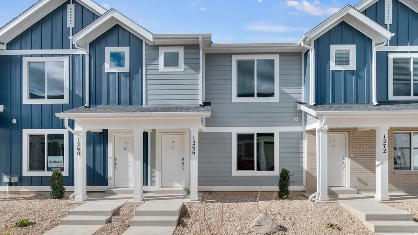Contemporary townhome exterior featuring dual-tone siding, white trim, and a covered entry