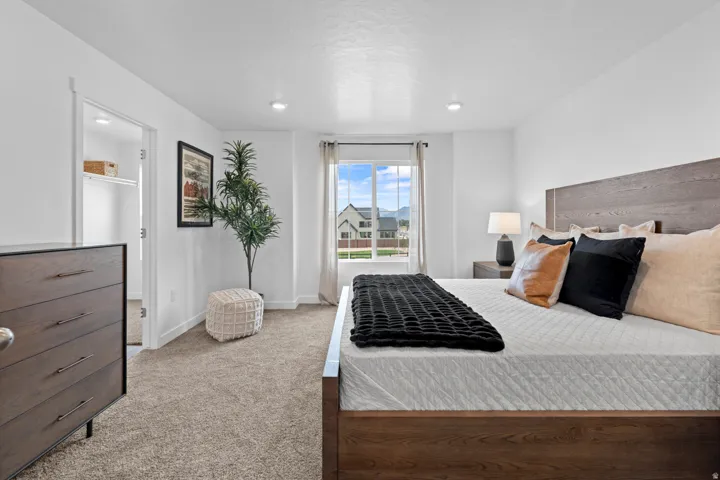 Plush carpeting, recessed lighting, and a window with a mountain backdrop