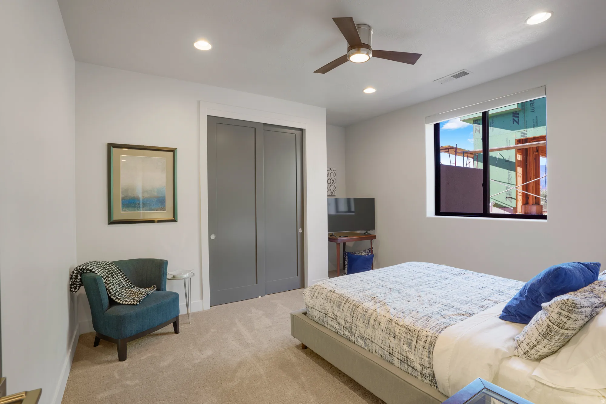 Recessed lighting, ceiling fan, expansive window, neutral carpet flooring, and a built-in closet with sliding doors