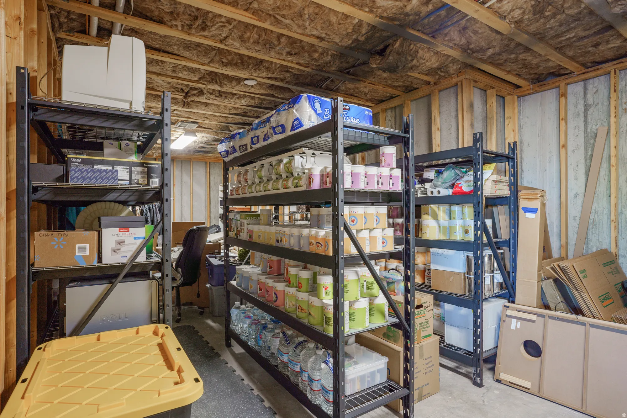 Unfinished basement space featuring exposed wood framing, ceiling insulation, and concrete flooring