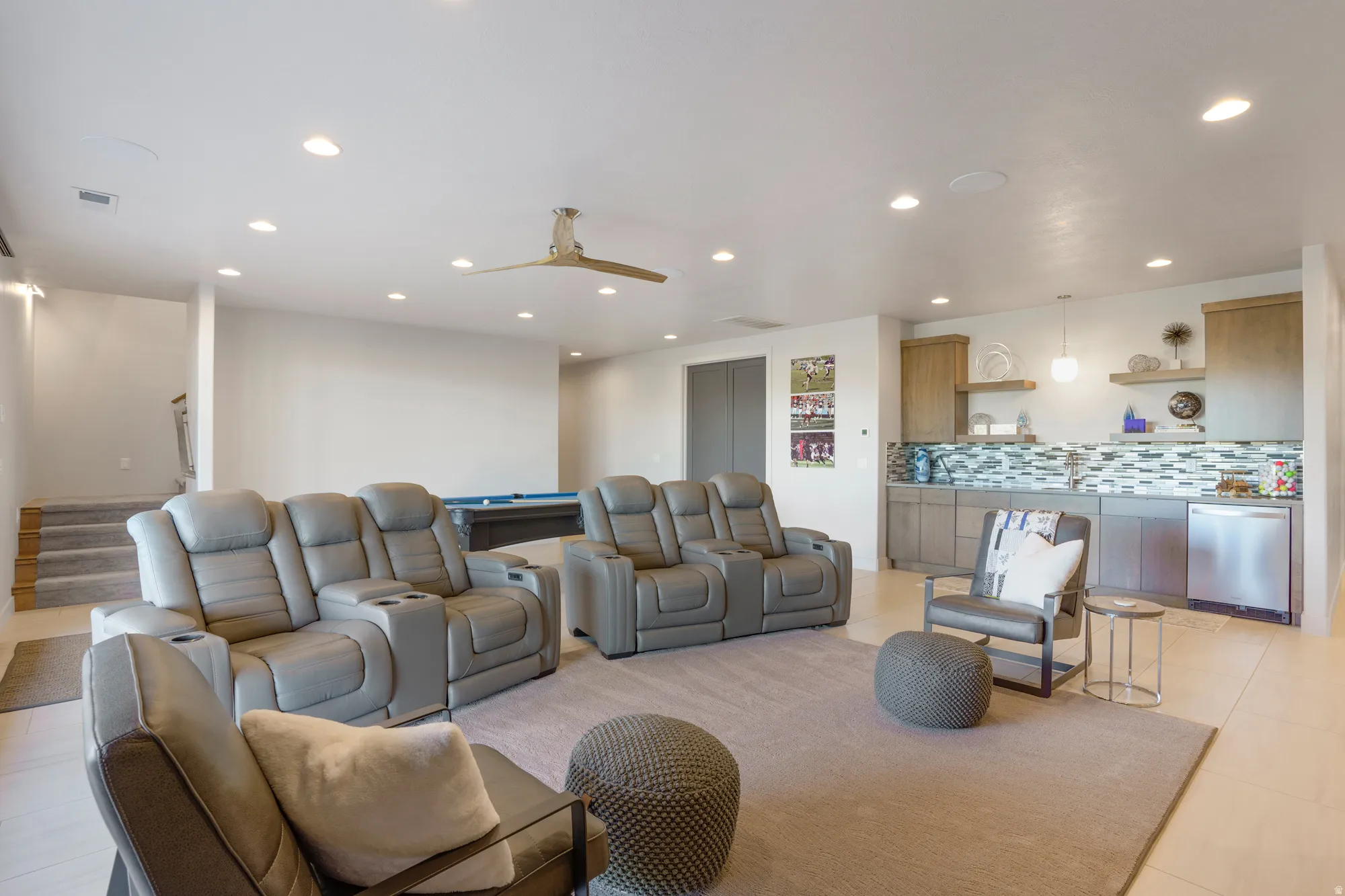 Recessed lighting throughout, modern ceiling fan, built-in wet bar with tiled backsplash, stainless steel dishwasher, and built-in cabinetry
