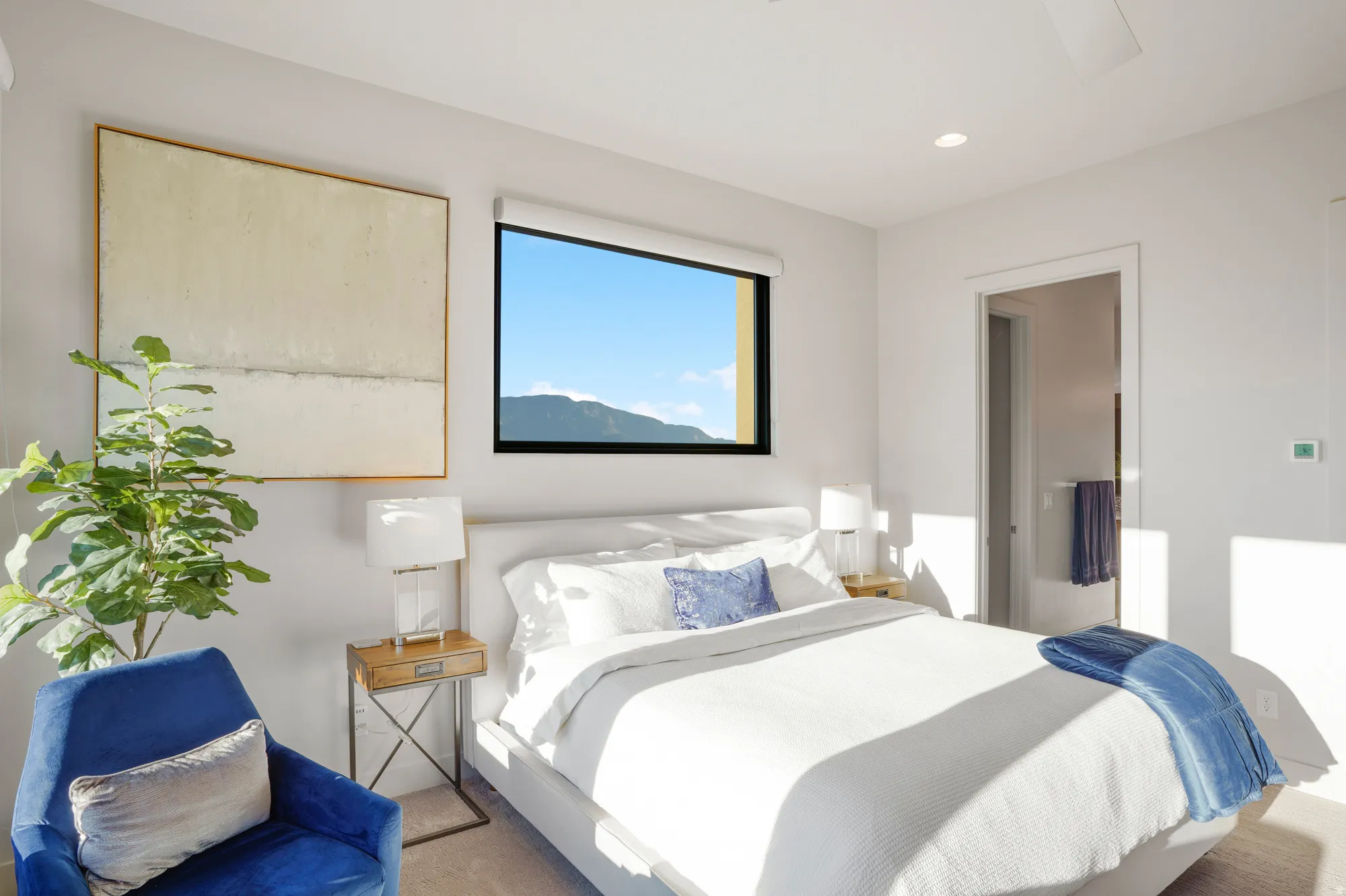 Recessed lighting, ceiling fan, large window, white walls, and a doorway