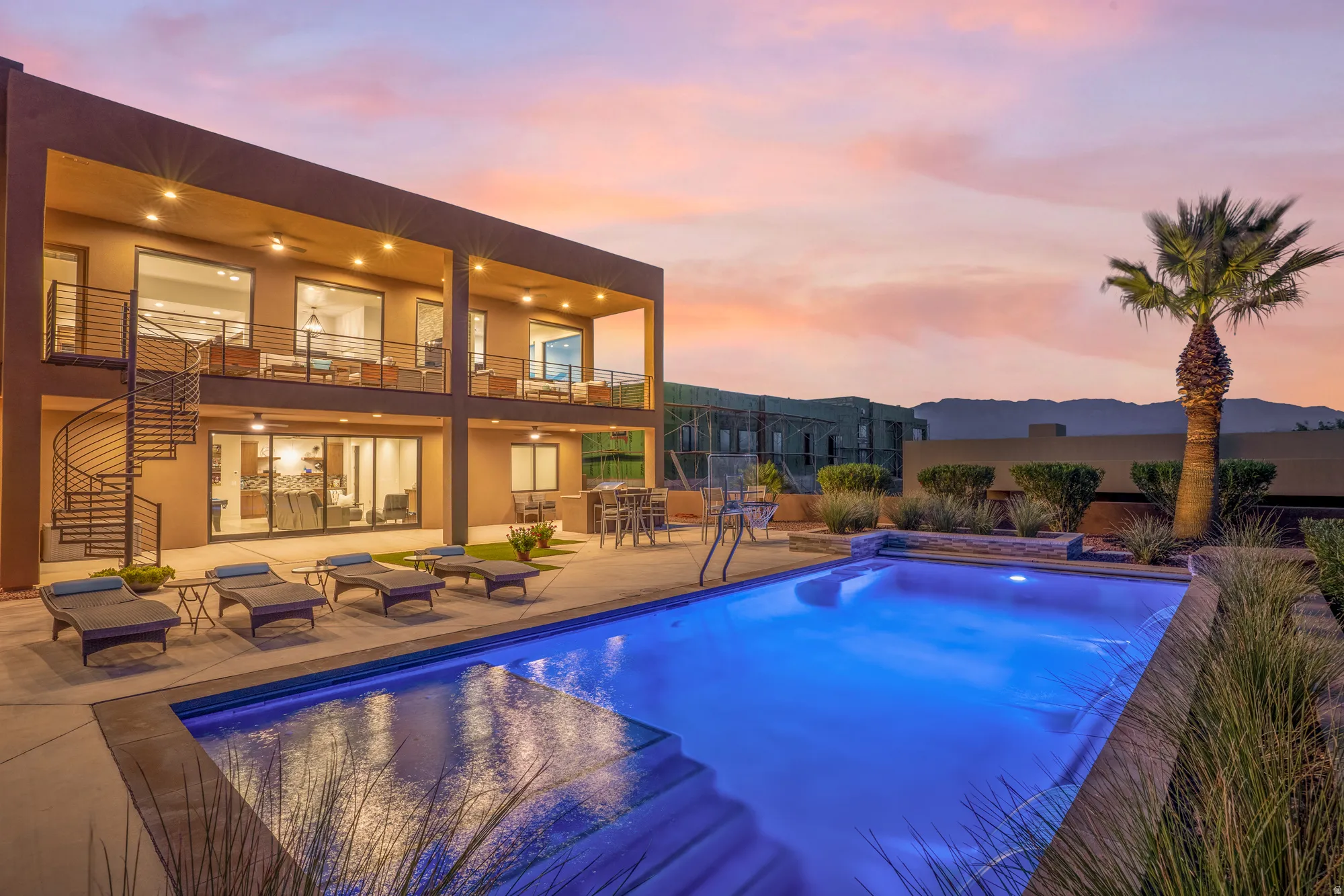 Two-story contemporary exterior with a spiral staircase, multiple covered balconies, a private swimming pool, and low-maintenance landscaping
