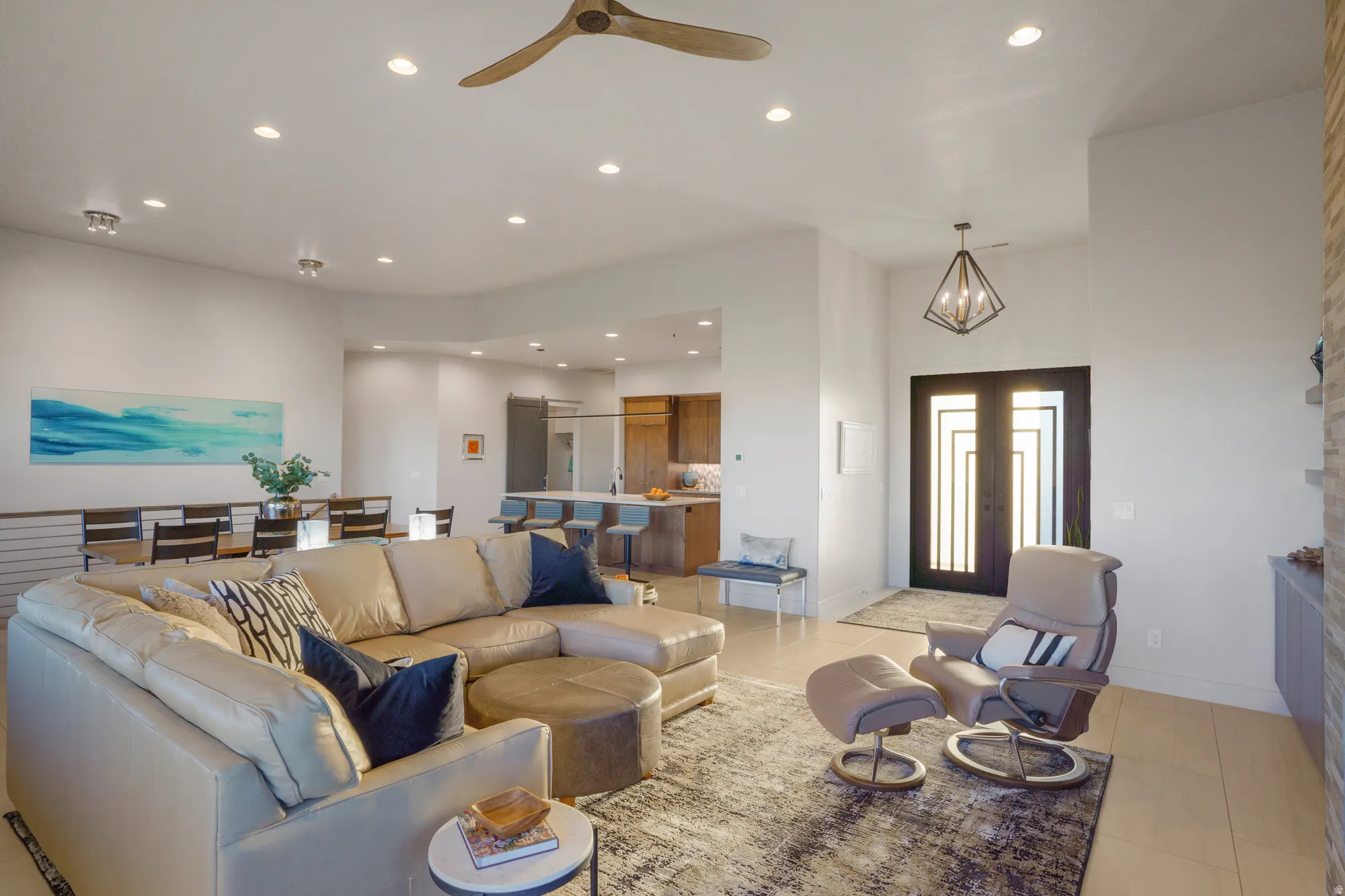 Recessed lighting throughout, high ceilings, large double entry doors, contemporary geometric entry light fixture, and a ceiling fan