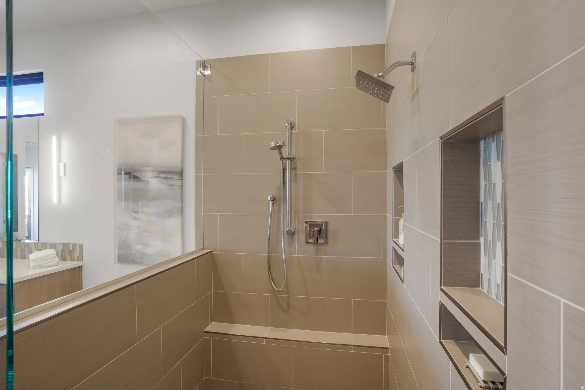 Walk-in shower with tiled walls and a built-in bench