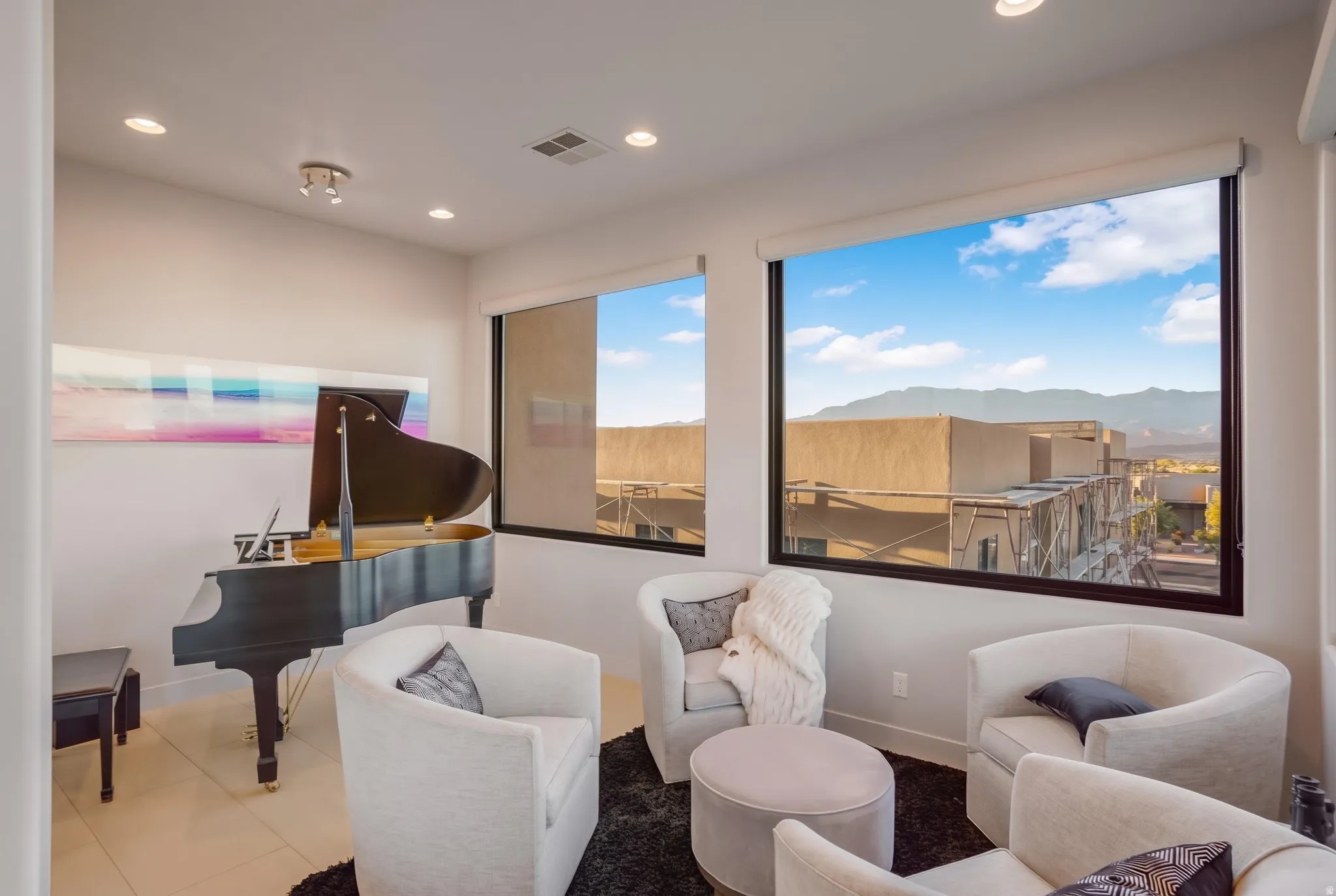 Recessed lighting, large windows with black framing, roller window shades, and light-toned tile flooring