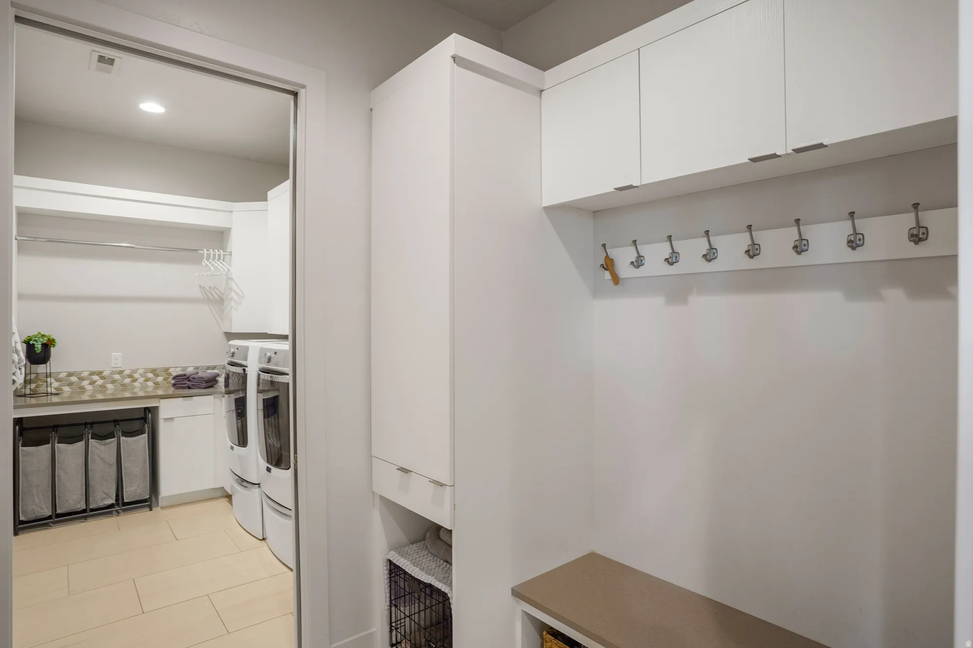 Built-in storage cabinetry, bench seating, and wall-mounted hooks