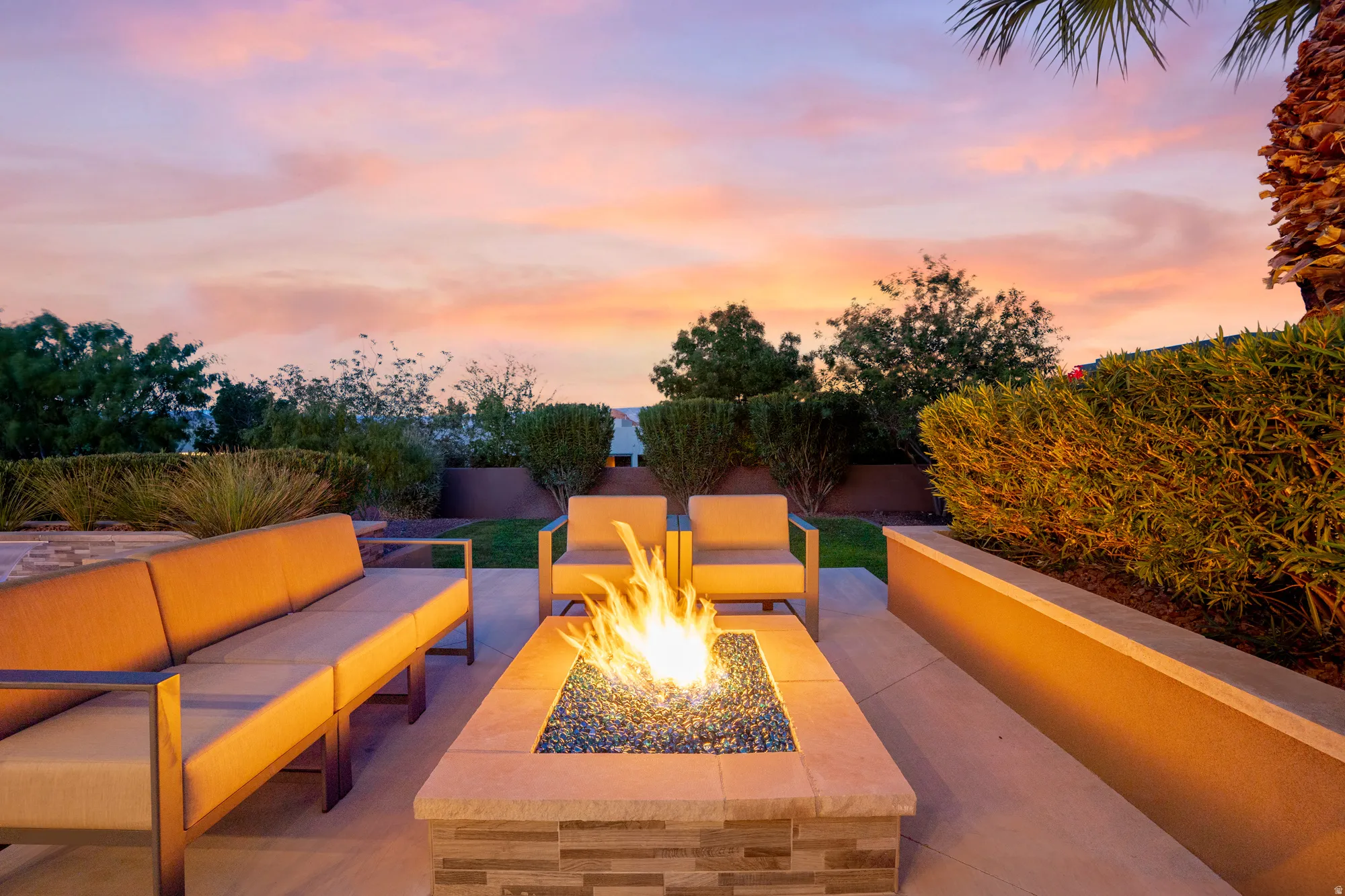 Hardscaped patio with a stone-clad fire pit and integrated seating