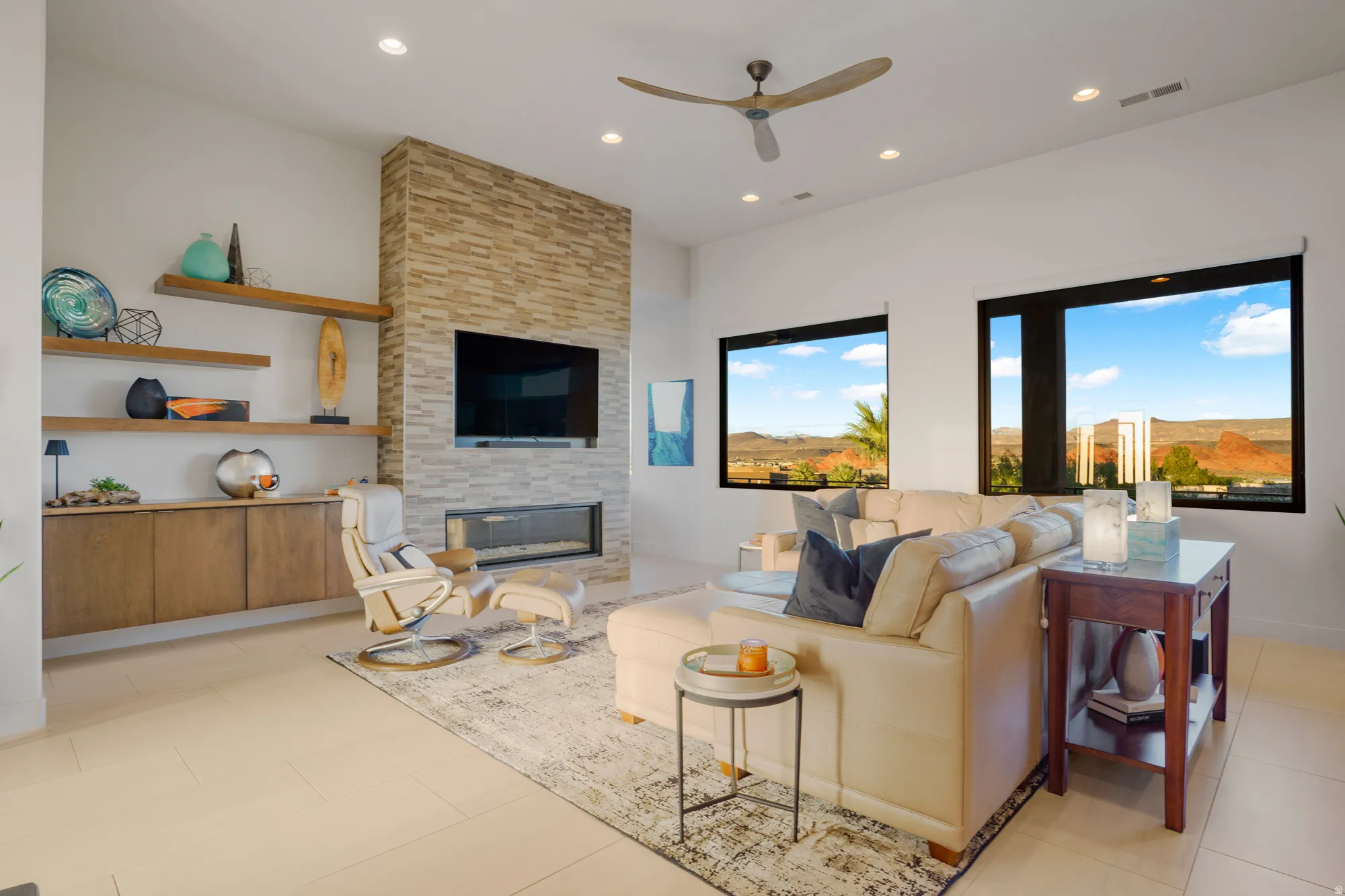 Stone-clad fireplace with an integrated linear fireplace, recessed lighting, and a ceiling fan