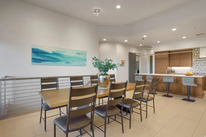 Recessed lighting, wood-finish flooring, stainless steel railing, wood-finish cabinetry, and a tile backsplash