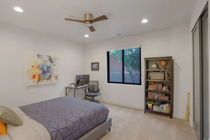 Recessed lighting, ceiling fan, window with exterior landscaping, built-in shelving, and carpeted flooring