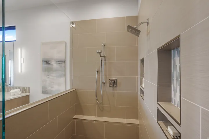 Walk-in shower with tiled walls and a built-in bench