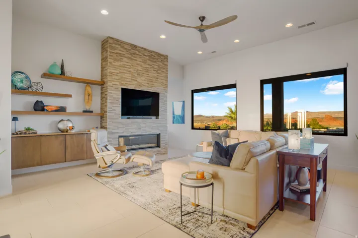 Stone-clad fireplace with an integrated linear fireplace, recessed lighting, and a ceiling fan