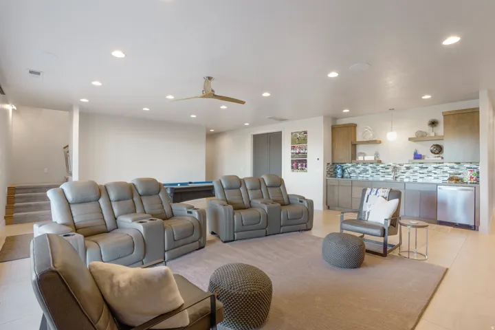 Recessed lighting throughout, modern ceiling fan, built-in wet bar with tiled backsplash, stainless steel dishwasher, and built-in cabinetry