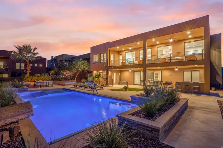 Expansive backyard featuring a rectangular swimming pool, integrated spa, and surrounding hardscaping