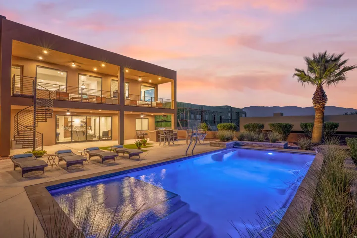 Two-story contemporary exterior with a spiral staircase, multiple covered balconies, a private swimming pool, and low-maintenance landscaping