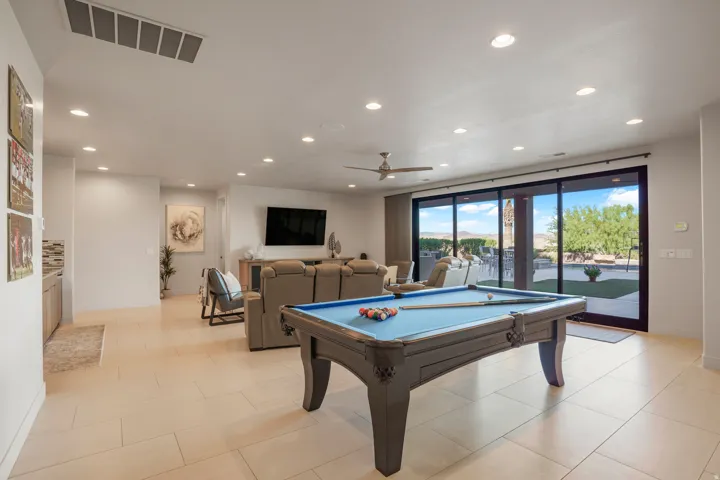Expansive open-concept living area featuring light-toned flooring, recessed lighting, and a ceiling fan