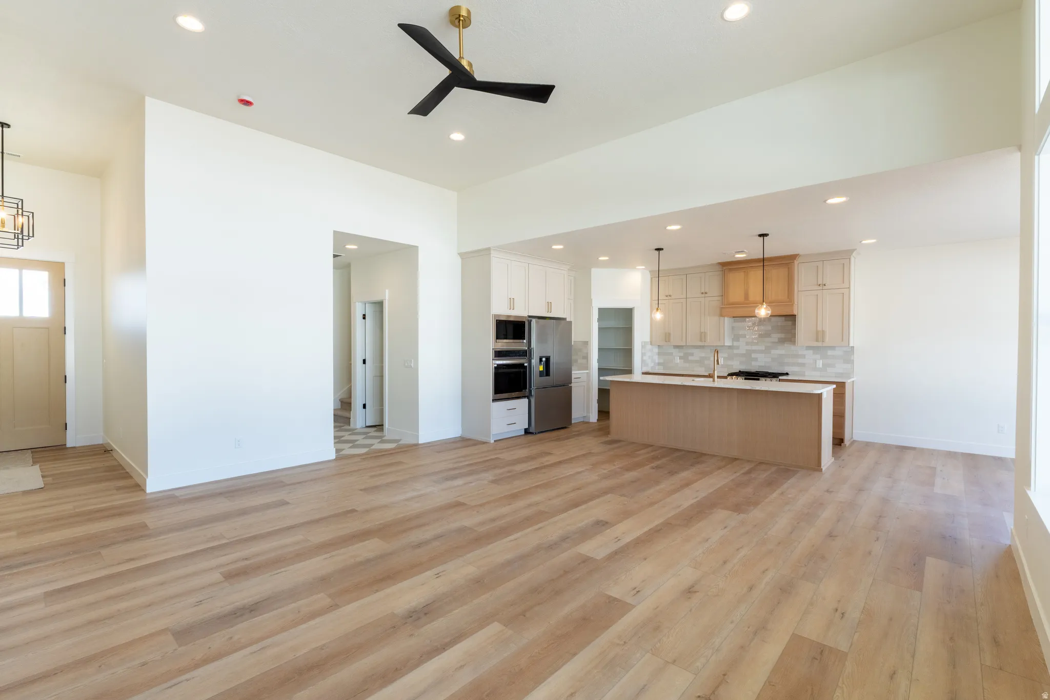Wood-finish flooring throughout, vaulted ceiling, recessed lighting, and a modern ceiling fan