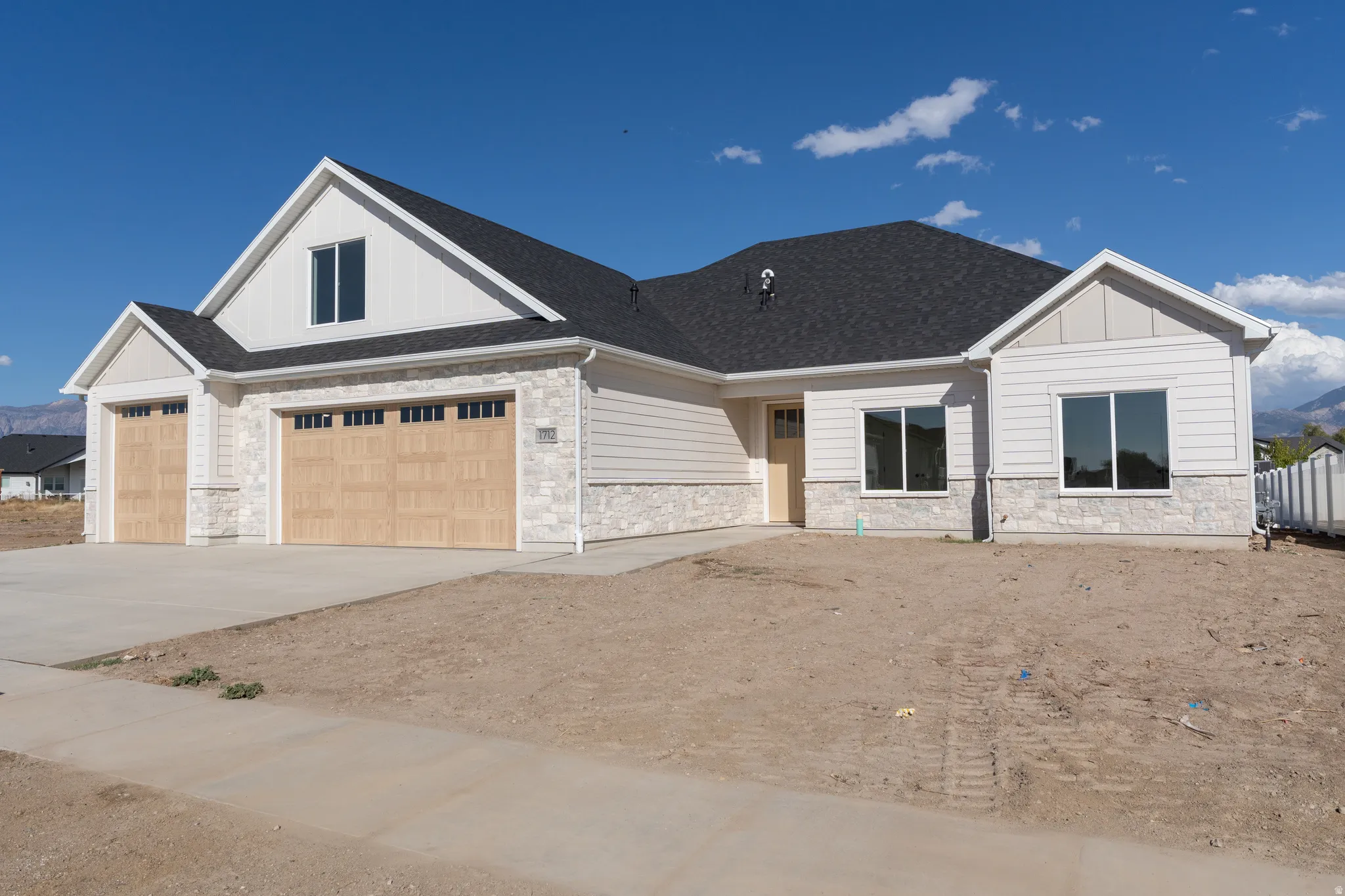 Contemporary exterior with light-colored siding and stone veneer accents
