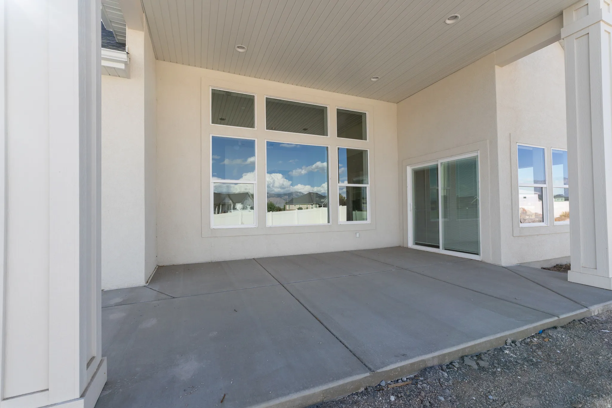 Expansive covered patio with concrete slab flooring and recessed lighting