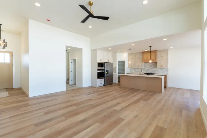 Wood-finish flooring throughout, vaulted ceiling, recessed lighting, and a modern ceiling fan