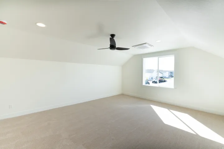 Vaulted ceiling, recessed lighting, ceiling fan, expansive window, and neutral . carpeting. upstairs loft for extra living space.